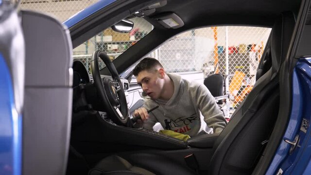 Disabled Young Man Detailing Sports Car Interior In Auto Body Shop