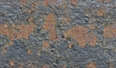 Black and red flaking rust on steel surface