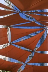 Creative outdoor canopy construction of dark orange colored fabric triangle awnings from the sun...