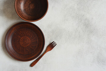 eco friendly handmade ceramic tableware top view with copy space for text and design, clay empty plate flat lay, cutlery and table setting, minimalism and ceramics tableware
