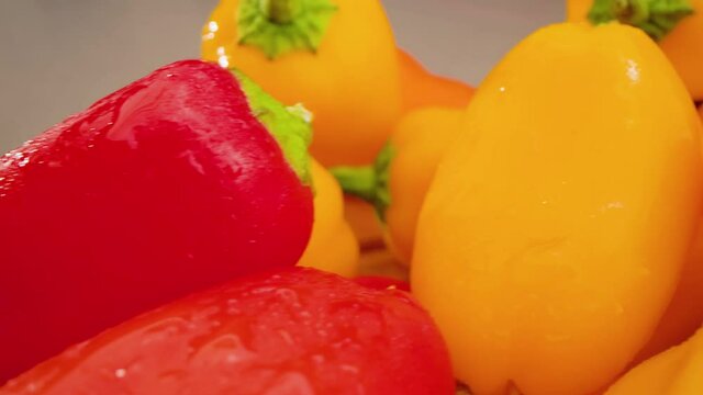 Mini Peppers Left to Right Above on Cutting Board Macro. macro view of mini peppers on a cutting board moving forward from left to right above stacked peppers