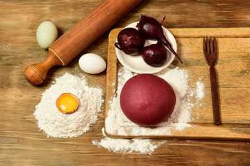 Beet dough for noodles, with ingredients on the table