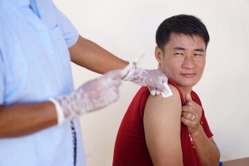 Concept : vaccination. Handsome  Asian man feels fear, hesitated, stressed and doubtful about...