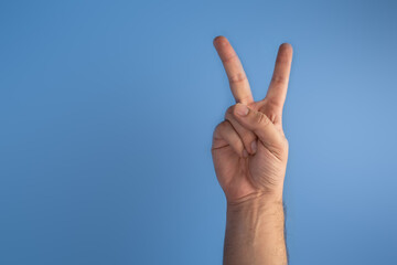 hand on blue screen making number 2