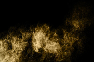 Golden powder explosion on black background. Freeze motion.