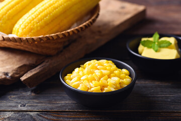 Sweetcorn and butter in a bowl on wooden background