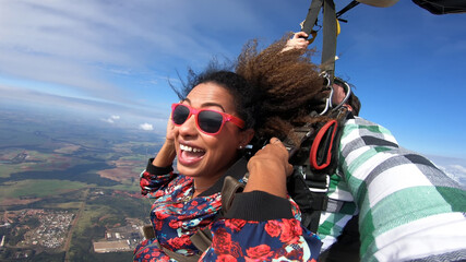 Beautiful black woman practicing skydiving. Tandem jump with selfie image. - 441069702