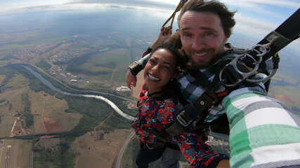 Beautiful black woman practicing skydiving. Tandem jump with selfie image. - 441069716