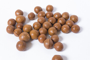 Macadamia nuts on white background. Cracked macadamia - organic and healthy food