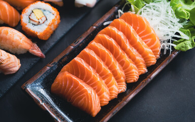 Salmon Sashimi in Japanese buffet restaurant menu.Fresh salmon fillet on black plate salmon...