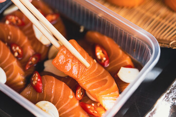 Fresh raw salmon slide marinated in a mild soy-sauce based brine on delivery go box.Asian people eating sashimi set Japan restaurant.salmon sashimi.Asian Food Menu.seafood sashimi.korean japan food.
