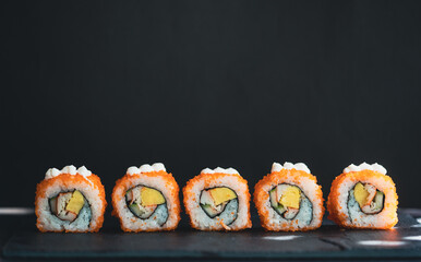California sushi rolls in closeup isolated black background, Set Sushi maki on black background for menu, Japanese food.California Maki Sushi with Masago - Roll made of Crab Meat, egg, Cucumber.