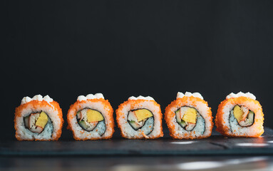 California sushi rolls in closeup isolated black background, Set Sushi maki on black background for menu, Japanese food.California Maki Sushi with Masago - Roll made of Crab Meat, egg, Cucumber.
