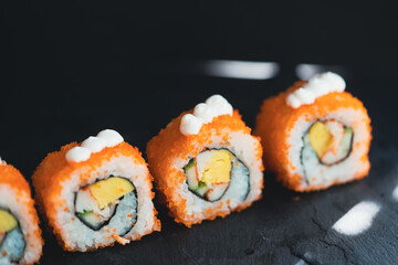 California sushi rolls in closeup isolated black background, Set Sushi maki on black background for menu, Japanese food.California Maki Sushi with Masago - Roll made of Crab Meat, egg, Cucumber.