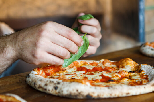 Original Italian Neapolitan pizza Margherita with melted mozzarella cheese, fresh basil leaves