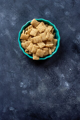 Chex cereal in a teal container on a dark background with copy space.