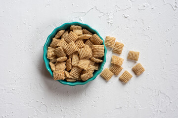 Chex cereal in teal container on white textured surface.