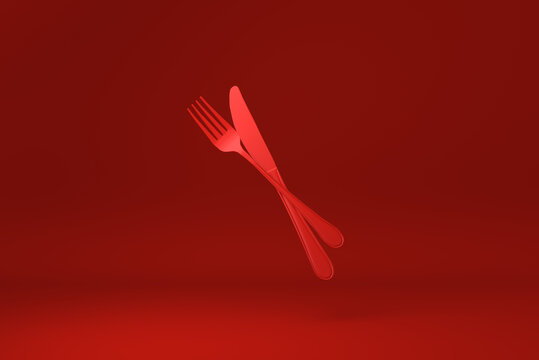 Red Fork and knife floating in Red background. minimal concept idea creative. monochrome. 3D render.