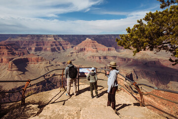 Family standing on the overlook in the Grand Canyon with no people surrounded.