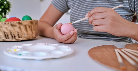 Woman painting Easter eggs at home. family preparing for Easter. Hands of a girl with a easter egg