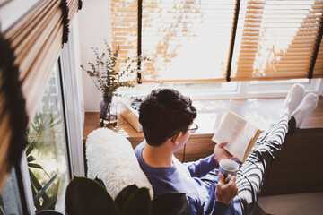 Young asian male reading a book at home, Relaxation concept.