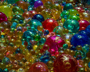 Fototapeta na wymiar Water marbles with gold powder in the sunlight