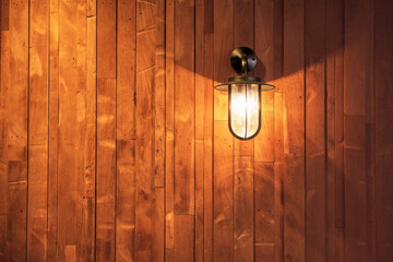 switched on lamp bracket at the wooden wall