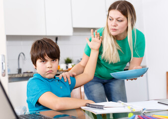 Boy refusing to eat, hands gesturing no to plate with breakfast