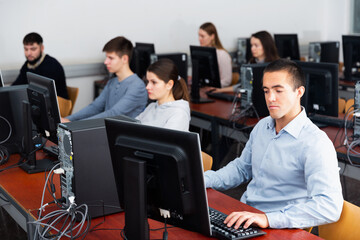 Fototapeta premium Portrait of adult concentrated students at computers in university computer class