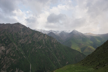 Idyllic winter landscape with hiking trail in the mountains. Rocks, snow and stones in mountain valley view. Mountain panorama.
