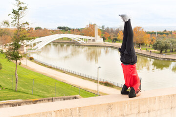 Man doing headstand exercise outdoors in a park