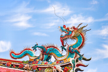 Beautiful dragon crawling on the decorative tile roof in Chinese temples. Colorful roof detail of...