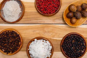 A set of spices on a wooden surface.