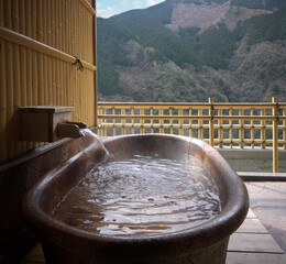 Japanese traditional open air private onsen bathtub with  autumn view with mountains and forest