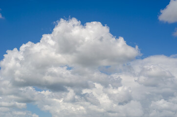 A blue summer sky with white clouds. White-gray clouds turning i