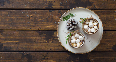 Two cups of coffee and fir cone  on old wooden table close up