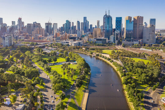 Aerial View of a river flowing through parkland toward a city skyline