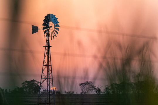 Windmill against a smoky sunset in drought conditions