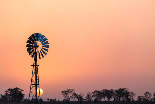 Windmill against a smoky sunset in drought conditions