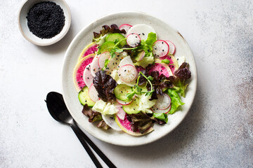 Purple and white radish and mixed salad leaves fresh salad on stone plate close up. Flat lay. Copy space