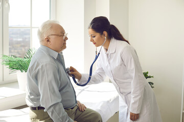 Doctor putting stethoscope on patient chest listen heartbeat and lungs breath. Elderly male person exam at hospital ward. Cardiologist physician appointment. Nursing home clinic service for pensioner - obrazy, fototapety, plakaty