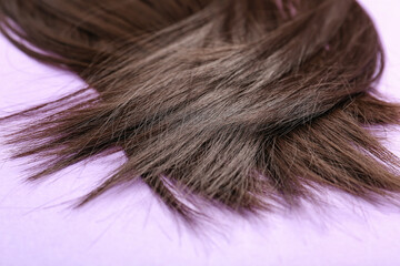 Beautiful brown hair on color background, closeup