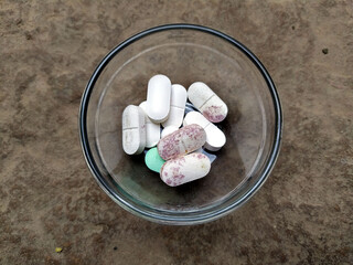 some medicine tablets put in a glass bowl