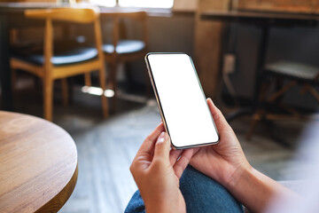 Mockup image of a woman holding mobile phone with blank white desktop screen