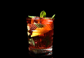 Glass of tasty ice tea with lemon on dark background