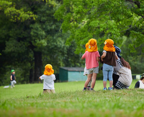 夏の公園で遊んでいる保育園の園児たちの様子