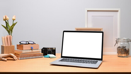 Fototapeta premium Mock up computer laptop, books and pencil holder on wooden desk.