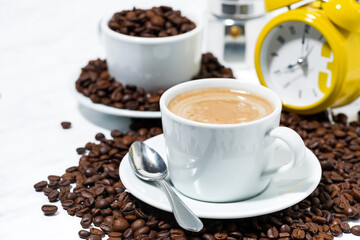 espresso cup on coffee beans on white background, closeup