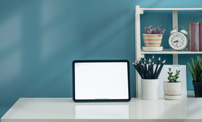 Mockup blank screen tablet and decorate object on white table and light blue wall.