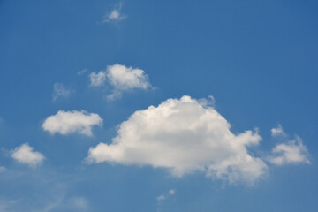 Beautiful cumulus clouds against the blue daytime sky.